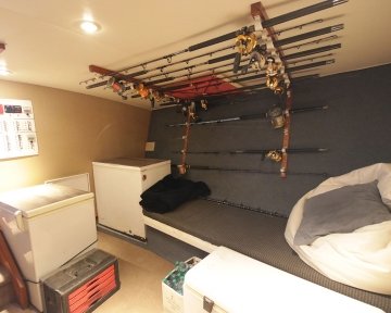 Inside a boat cabin with fishing rods on ceiling