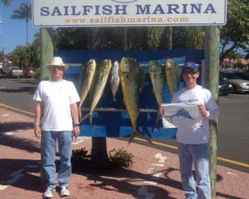 Two men in front of the sailfish marina sign