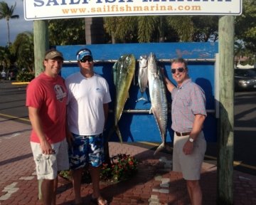 Three men in front of the sailfish marina sign