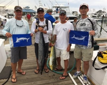 Guys holding blue marlin flags and fish