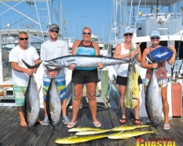 Men and women posing with caught fish